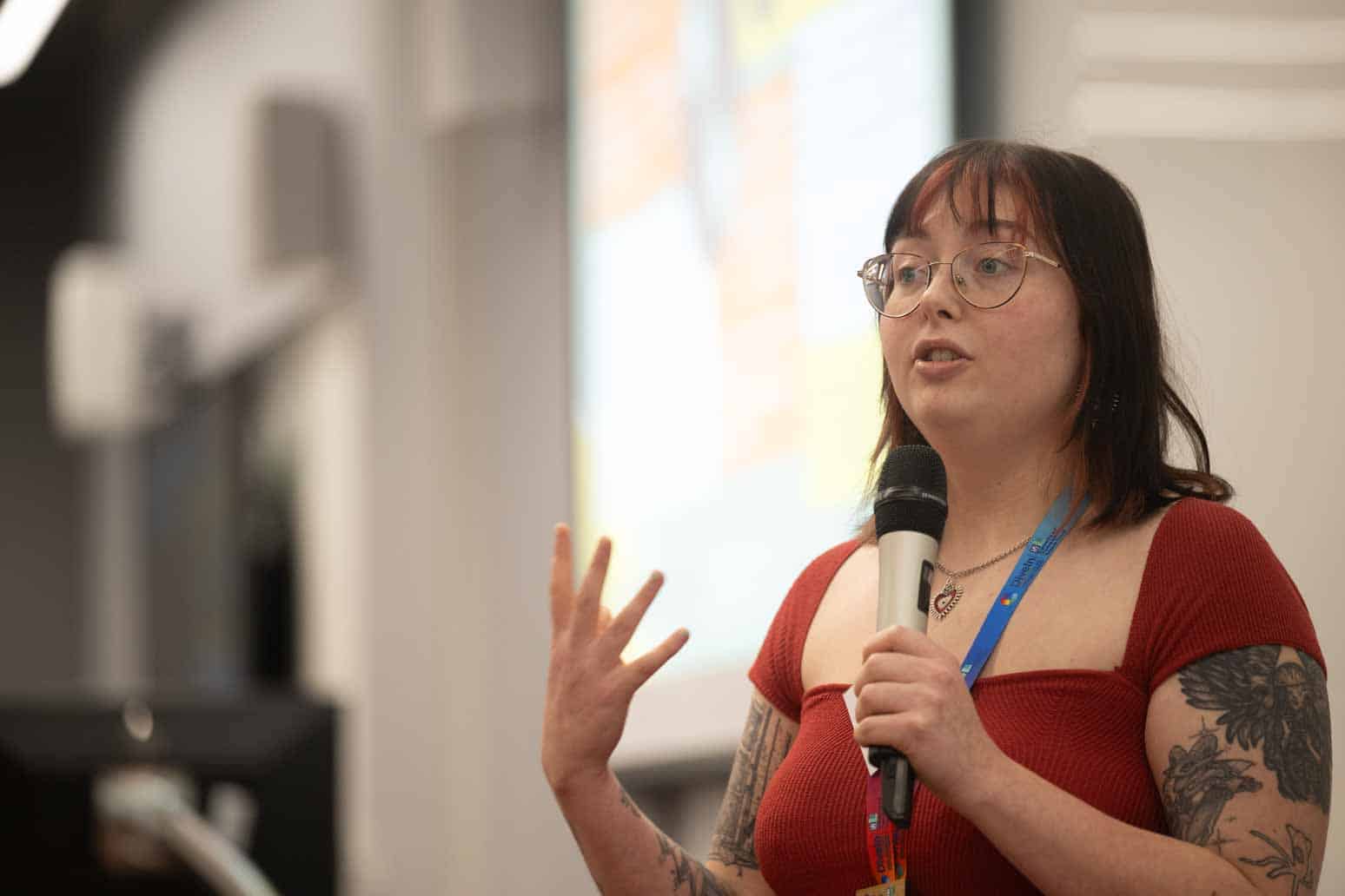 Amy Eden (DiveIn PGR - Cohort 1) is holding a microphone and presenting at the Project Scope and Connect Workshop 2025